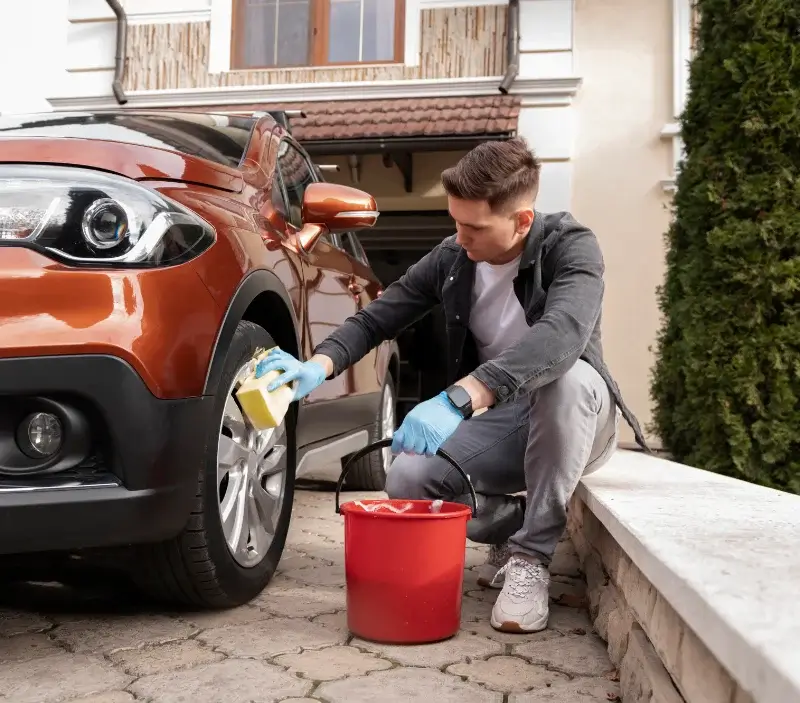 Lavage auto à domicile Herbeuville : professionnel intervenant sur un véhicule